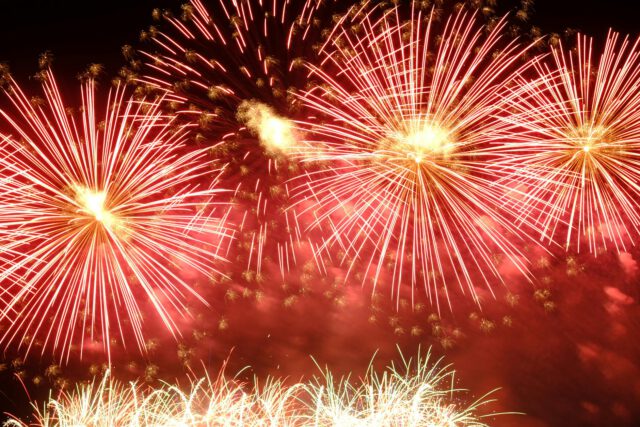 dazzling red fireworks burst at night sky